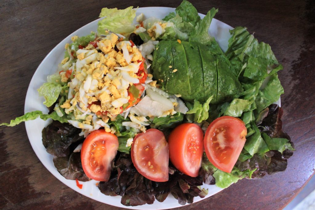 Malaspina salad with lettuce, tomato, avocado, egg, salted cod, and gulas